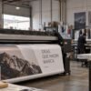 Impresión digital de gran formato en taller industrial con equipo de impresión, materiales y operarios